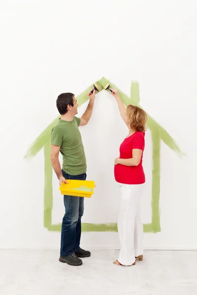 Couple expecting a baby - painting their home — Stock Photo, Image