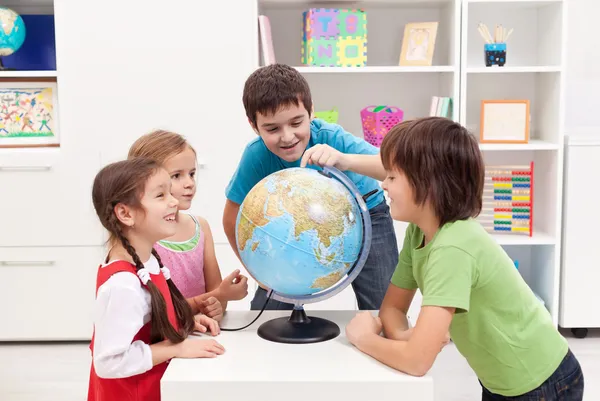 Kinderen kijken naar earth globe — Stockfoto