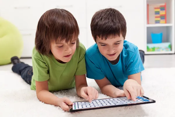 Boys playing labyrinth game on tablet computer — Stock Photo, Image