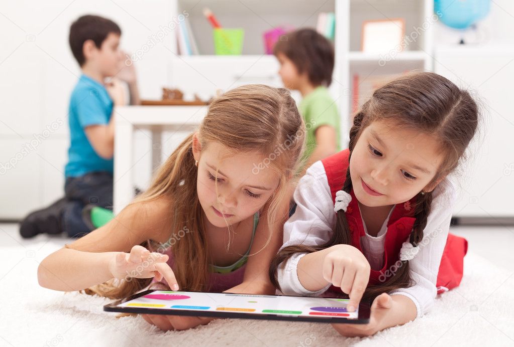 Little girls playing on a tablet computing device