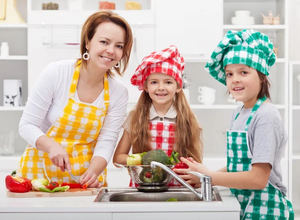 Τα παιδιά βοηθώντας την μητέρα της στην κουζίνα — Φωτογραφία Αρχείου