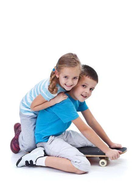 Niños felices jugando con monopatín —  Fotos de Stock