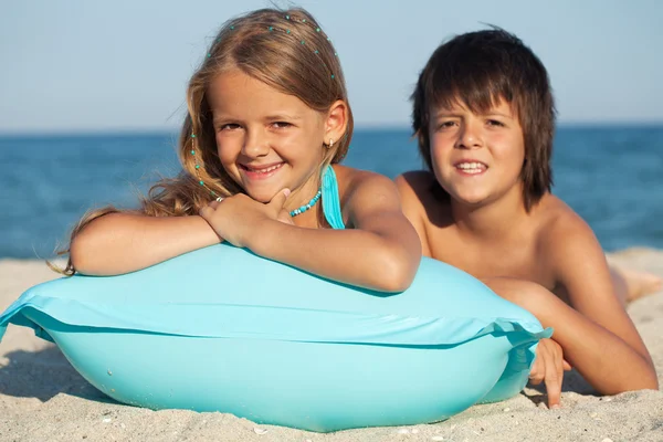Kinderen met opblaasbare raft op het strand — Stockfoto