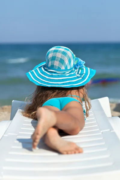 Kis lány a tengerparton, pihentető egy nyugágy — Stock Fotó