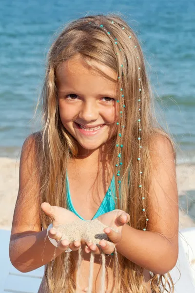 Menina na praia brincando com areia — Fotografia de Stock