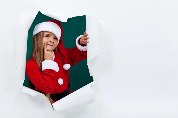 Μικρό κορίτσι σε ρούχα santa σπάσιμο έξω από χαρτί στρώμα — Φωτογραφία Αρχείου