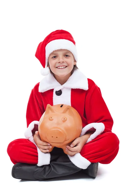 Happy boy in santa costume with piggy bank — Stock Photo, Image