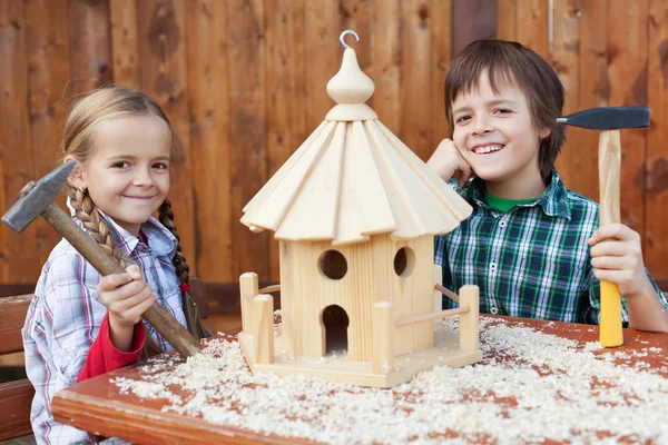 Crianças felizes construindo uma casa de pássaros — Fotografia de Stock