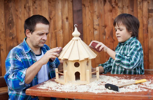 Father and son working on bird house together — Stock Photo, Image