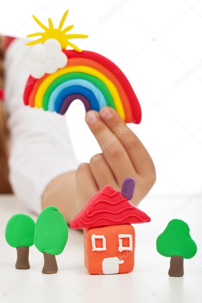 Clean environment concept - child hand with colorful clay figure