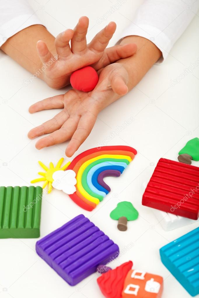 Child playing with colorful clay - closeup on hands