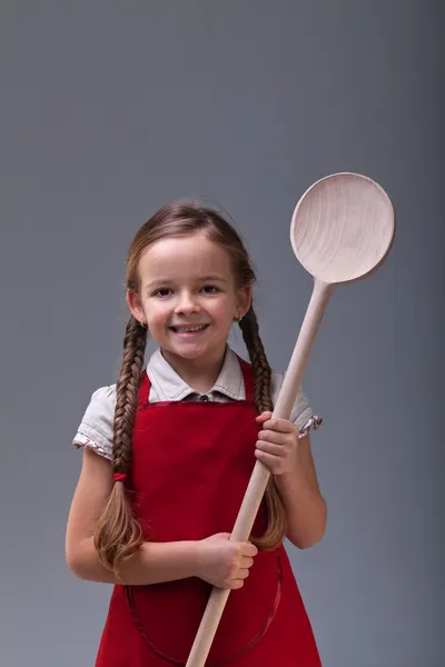 Mladá dívka s velkou dřevěnou lžící — Stock fotografie