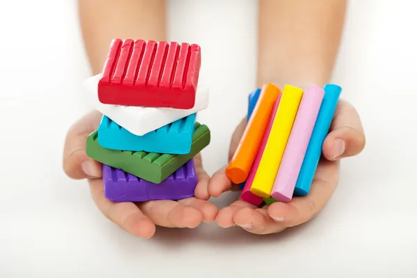 Дитячі руки з барвистою глиною моделювання — стокове фото