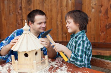 Father and son building a bird house together clipart
