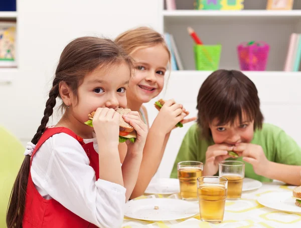 Niños masticando sándwiches — Foto de Stock