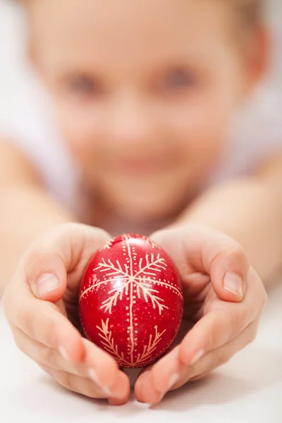 Child hands holding traditional decorated easter egg — Stock Photo, Image