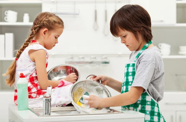 Grumpy kids doing home chores - washing dishes — Stock Photo, Image