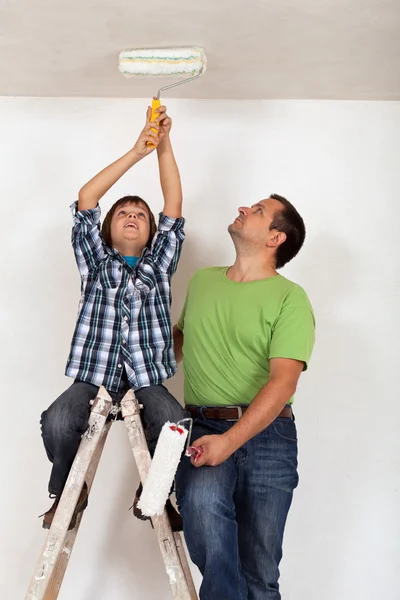 Chłopiec pomagał ojcu do malowania pokoju — Zdjęcie stockowe