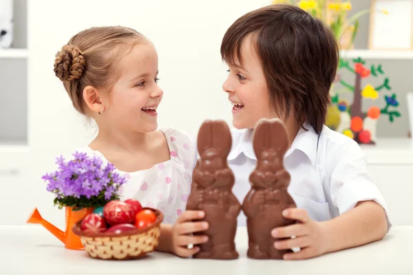 Щасливі діти у Великодній час з великими шоколадними кроликами Стокова Картинка