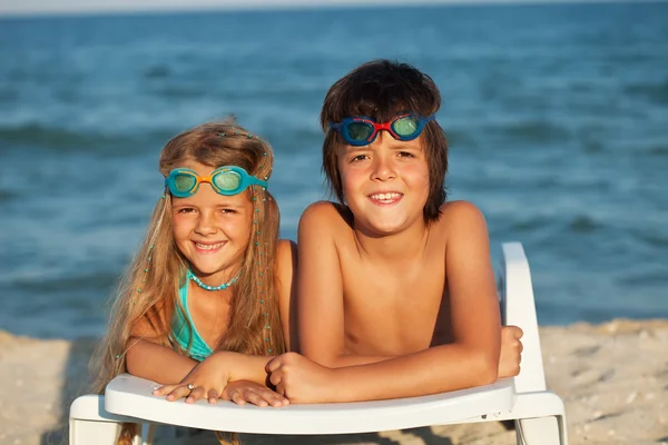 Kinder liegen mit Schwimmbrille auf Strandkorb — Stockfoto