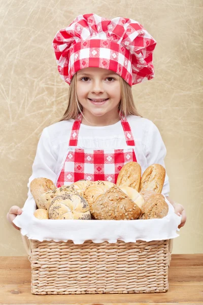 Happy baker holding a basket with fresh products — Stock Photo, Image