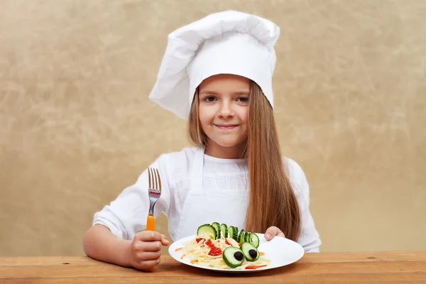 Criança feliz com chapéu de chef e prato de massas decorado — Fotografia de Stock