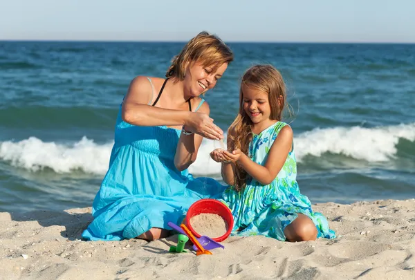 Kvinna och liten flicka på stranden — Stockfoto