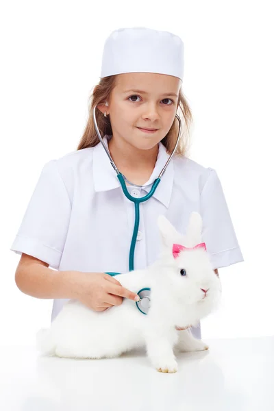 Niña jugando veterinaria con su conejo Imágenes de stock libres de derechos