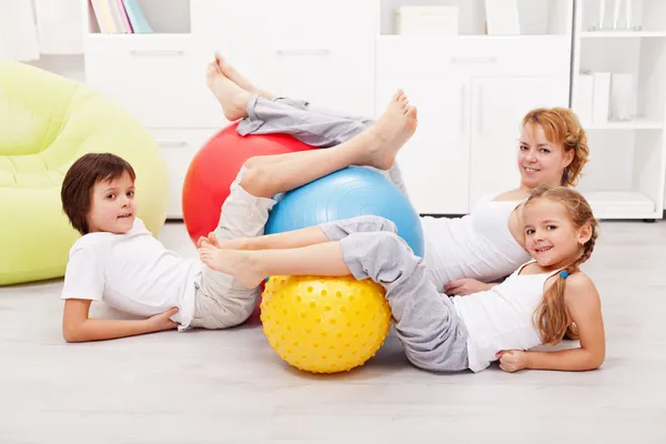 Glad frisk familj med stora gymnastiska bollar — Stockfoto