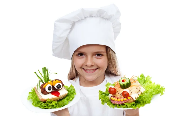 Criança chef sorridente feliz com sanduíches criativos — Fotografia de Stock