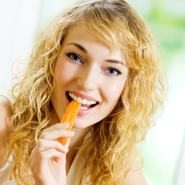 Jonge vrouw eten wortelen — Stockfoto