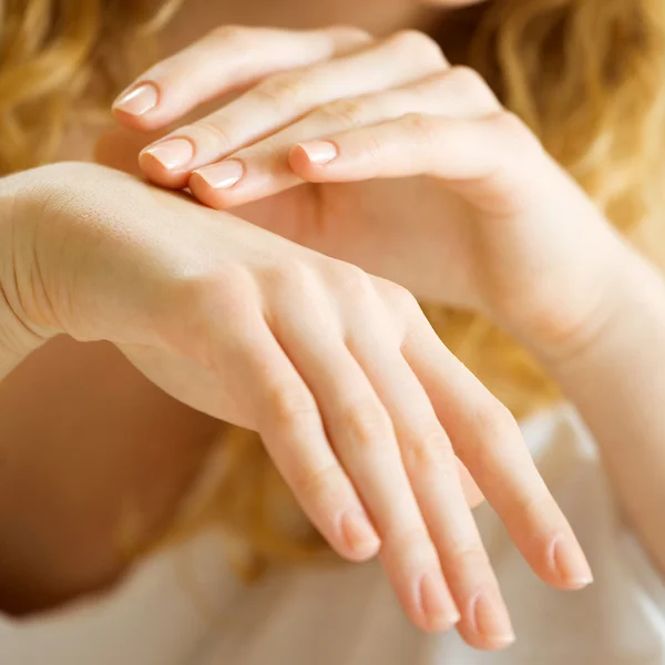 Gros plan de mains de femme appliquant de la crème — Photo