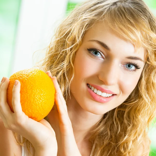 Jovem mulher sorridente com laranja — Fotografia de Stock