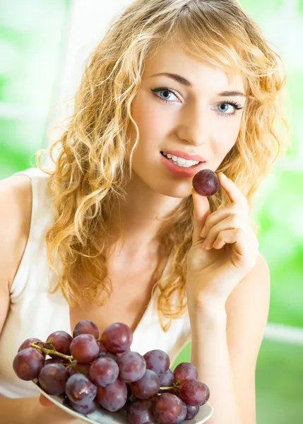 Jeune femme heureuse avec assiette de raisin — Photo