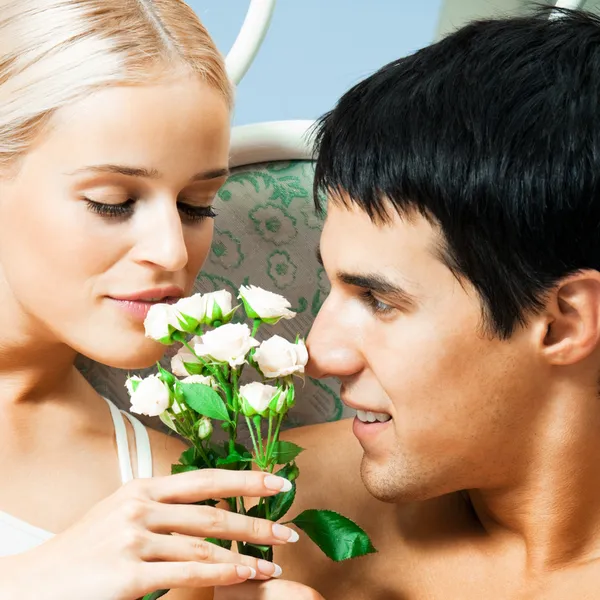 Fröhliches Paar mit Rosen, drinnen — Stockfoto