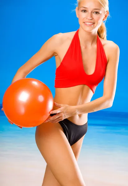 Jovem mulher brincando com bola na praia — Fotografia de Stock