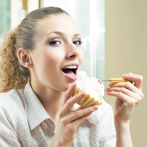 Vrolijke lachende blonde vrouw eten taart — Stockfoto