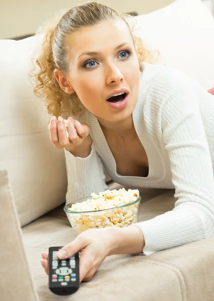 Leende kvinna tittar på tv hemma — Stockfoto