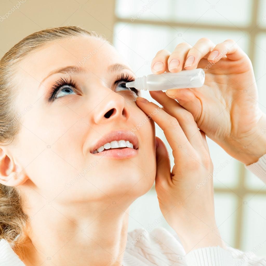 Woman dripping eye with eyes drops