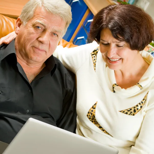 Alegre pareja de ancianos que trabajan con el ordenador portátil — Foto de Stock