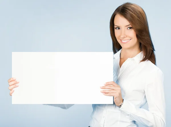 Businesswoman showing signboard, over blue Stock Photo