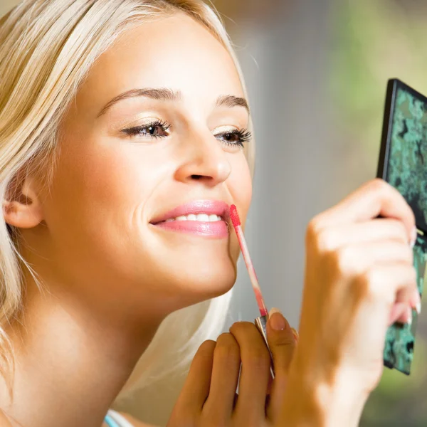 Happy beautiful woman applying lipstick — Stock Photo, Image