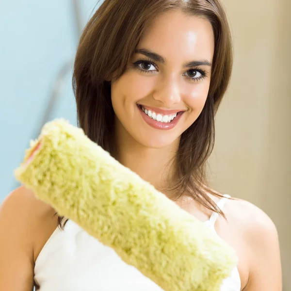 Woman with paint roller in new house — Stock Photo, Image