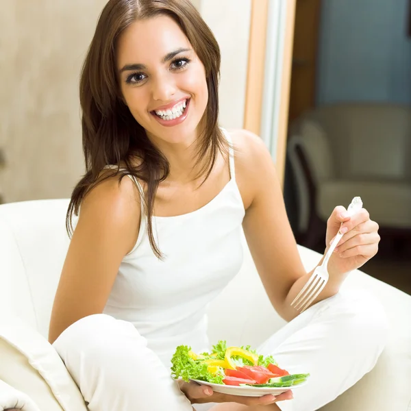 Молодая женщина с салатом, дома — стоковое фото