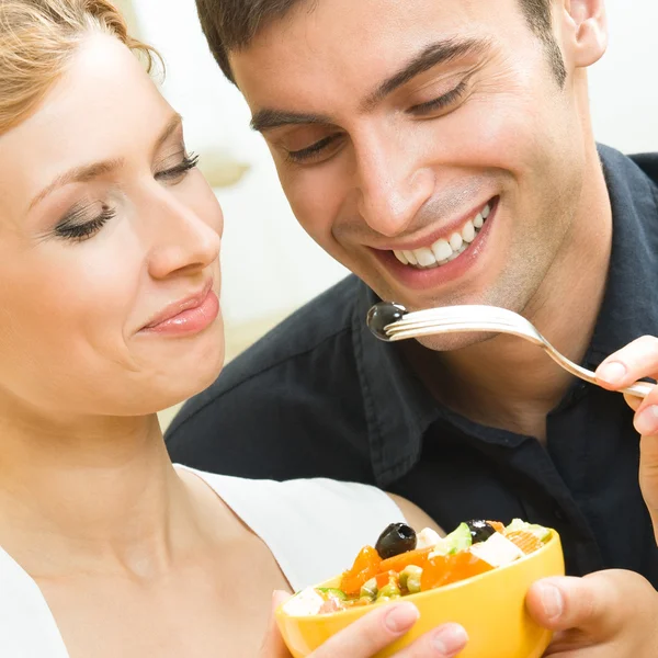 Cheerful young couple with vegetarian salad at home — Stok fotoğraf