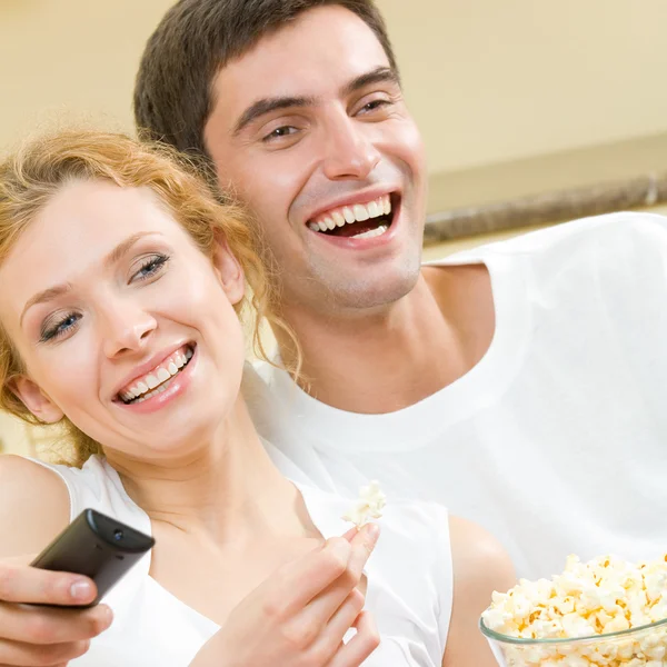 Joyeux jeune couple regardant la télévision ensemble — Photo