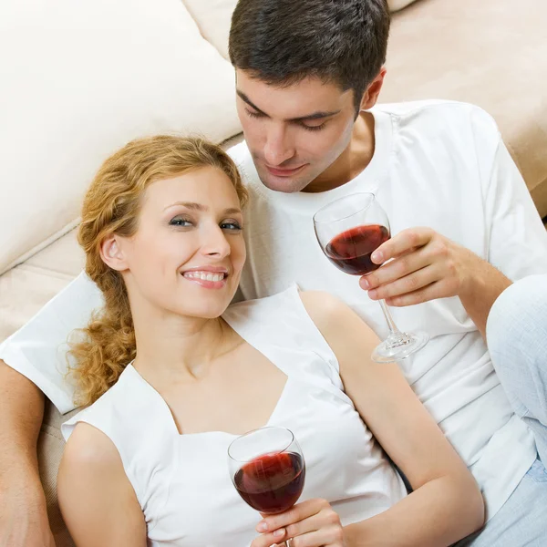 Casal alegre com copos de vinho tinto — Fotografia de Stock