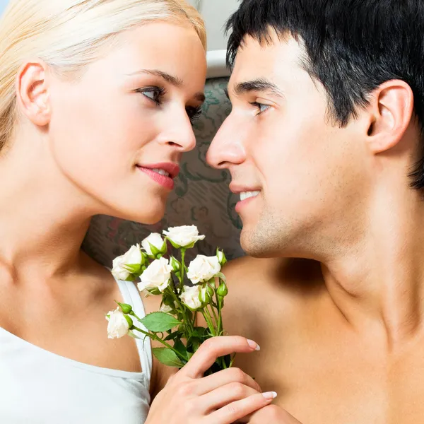 Fröhliches Paar mit Rosen, drinnen — Stockfoto