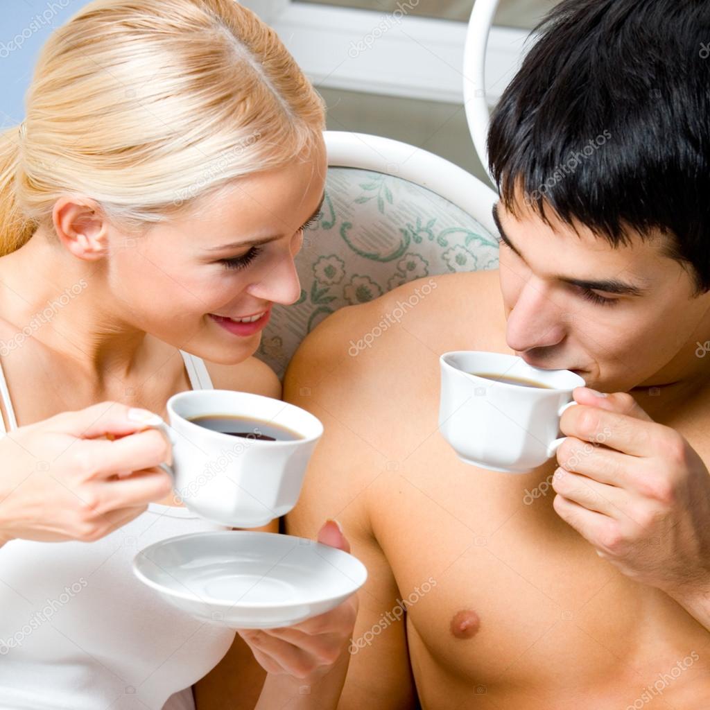 Cheerful couple with cups of coffee, indoor