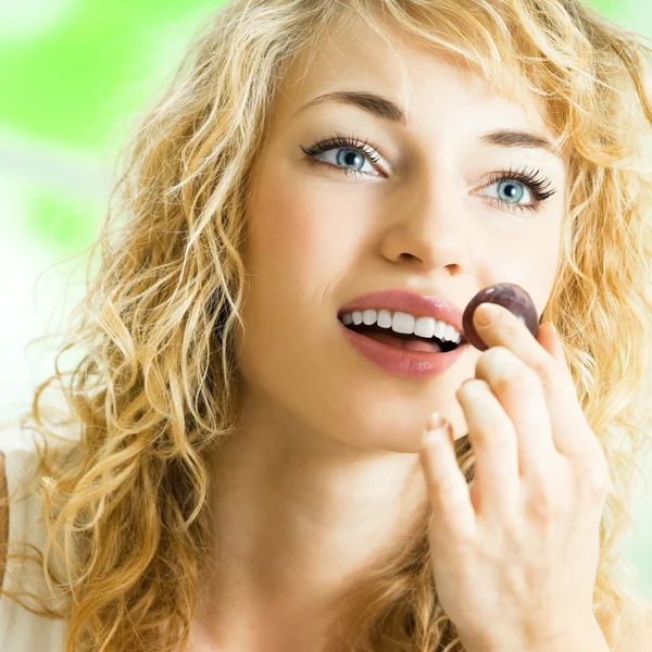 Junge glückliche Frau isst Weintrauben — Stockfoto